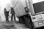 Férfiak dolgoznak a beszorult dán hússzállító kamion kiszabadításán, amely alatt beszakadt az úttest a XVII. kerületi Csömöri út 103. szám előtt december 29-én a déli órákban. A teherjármű a tengelyéig elmerült a vízcsőtörés miatt felázott talajban. Végül a BKV és a MÁV darujaival sikerült kiemelni.