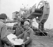 Wolfgang Krüger (j) a TAKRAF Kombinát vezetőszerelője magyar munkatársaival munka közben. A Mátraaljai Szénbányák bükkábrányi külfejtésű bányájában a lignittermelés növekedése szükségessé teszi a nagygépes művelés bevezetését. 