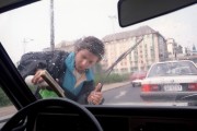 Ablakmosó fiú tisztítja egy gépkocsi szélvédőjét. Az autósok naponta találkoznak Budapesten a nagyforgalmú kereszteződésekben a szélvédőt mosó gyerekekkel. A szünidei pénzkeresésnek ez a módja sok veszélyt rejteget.