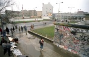  Berlin, 1990. március 6. Határátkelő az 1961 - 1989 között Nyugat- és Kelet-Berlint kettéosztó betonfalnál. Az előtérben utcai árusok különféle, a "betonfüggönnyel" összefüggő szuvenírokat kínálnak a látogatóknak . (A fal ledöntése 1989. november 9-i spontán akcióval kezdődött, azután az átkelés és vele a határ formálissá vált.) 