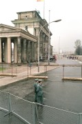  Berlin, 1990. március 6. Az 1961 - 1989 között Nyugat- és Kelet-Berlint kettéosztó betonfal mögött határőrök járőröznek. A háttérben a brandenburgi kapu látható. (A fal ledöntése 1989. november 9-i spontán akcióval kezdődött, az első betonszelvény eltávolítása - a Bernauer Strasse és az Acker Strasse sarkán - 1990. június 13-án történt.) 
