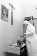  Pécs, 1990. március 12. Kapisztrána nővér gyertyát gyújt a pécsbányatelepi kórházban. A Szociális és Egészségügyi Minisztérium pályázatán nyert támogatás lehetővé tette, hogy a ferences betegápoló nővérek munkába állhattak a kórház geriátriai osztályán. A nővérek a betegek gondozása mellett vigasztalást nyújtanak a haldoklóknak, elbeszélgetnek magányos emberekkel és utógondozást is vállalnak. 