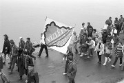 Nagymaros, 1989. április 4. Tüntetők vonulnak Zebegény és Nagymaros között, a Dunaparton. A Bajcsy-Zsilinszky Endre Baráti Társaság környezetvédő csoportja, a Duna Mozgalmak és más független szervezetek áprillis 3-án kirándulásra invitálták az érdeklődőket a Dunakanyarba, hogy Nagymaroson közös szemlén győződjenek meg, hol tartanak a leendő vízerőmű beruházási munkálatai. A déli órákra több ezren gyűltek össze az építkezés körülzárt területének kapujánál, ahol a szervezők tiltakozó beszédeket tartottak, követelve a nagyberuházás azonnali leállítását.