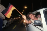 Sopron, 1989. szeptember 11. Egy NDK-beli állampolgár autójából kihajolva német zászlót lenget, amikor szeptember 10-én 24 órától mintegy ezer társával együtt saját okmányukkal elhagyják Magyarországot az ideiglenesen megnyitott határátkelőnél és Ausztrián keresztül az NSZK-ba távoznak.